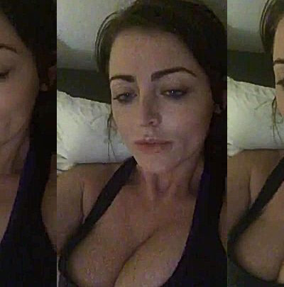 Sophie Dee teasing her big tits in her dark bedroom